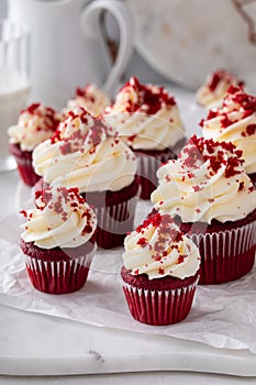 Red velvet cupcakes with cream cheese frosting on a marble board