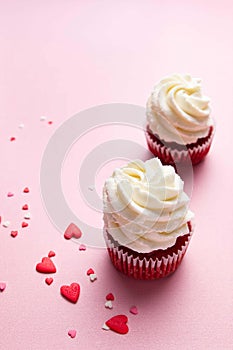 Red velvet cupcakes with cream cheese frosting on pink background. Valentine\'s Day concept. Top view, copy space.