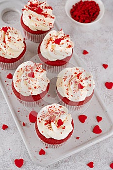Red velvet cupcakes with cream cheese frosting and red sugar hearts. Delicious dessert for Valentines day. Selective focus