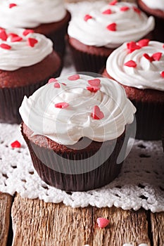 Red velvet cupcakes decorated with hearts close-up. vertical