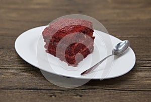 Red Velvet, fresh delicious diet cake at Dukan Diet on a porcelain plate with a spoon on a wooden background.