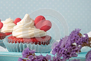 Red velvet heart cupcake with cream cheese frosting and a red heart for Valentine`s Day