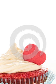 Red velvet heart cupcake with cream cheese frosting and a red heart for Valentine`s Day. Isolated on white background with copy