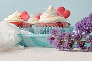 Red velvet heart cupcakes with cream cheese frosting and a red heart for Valentine`s Day. Top view with copy space