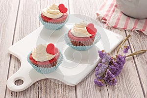 Red velvet heart cupcakes with cream cheese frosting and a red heart for Valentine`s Day. Top view with copy space