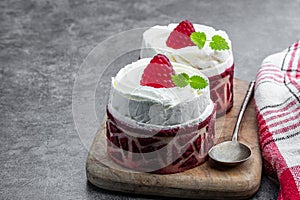 Red velvet mini cakes with whipped cream on gray background