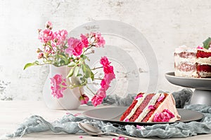 Red velvet naked cake with fresh roses and swiss buttercream on kitchen countertop