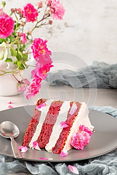 Red velvet naked cake with fresh roses and swiss buttercream on kitchen countertop