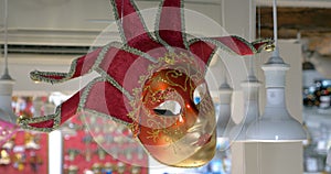 Red Venetian mask hanging in the store