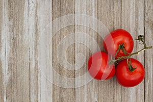 Red vine ripe tomatoes on weathered wood background