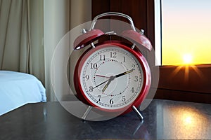 Red vintage alarm clock with beautiful sunrise