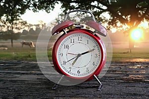 Red vintage alarm clock with beautiful sunrise