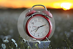 Red vintage alarm clock with beautiful sunrise