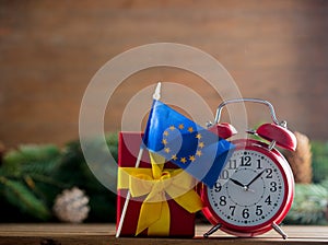 Red vintage alarm clock and gift box with Europe Union flag