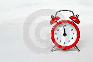 Red vintage alarm clock striking midnight (or midday)