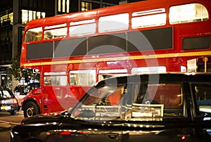 Red vintage bus and classic style taxi in London.