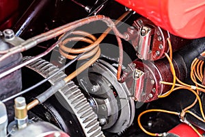 Red vintage car simple engine, detail on pipes, cables and serpentine drive belt pulley