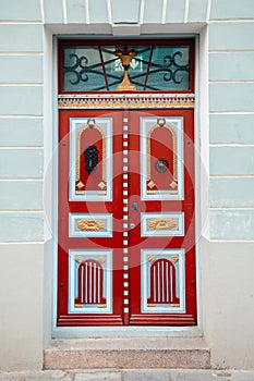 Red vintage door on a old building facade in old Tallinn city