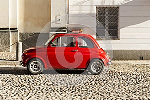 Red vintage italian car parked in the city center