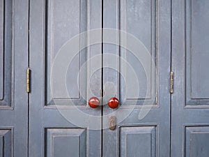 Red vintage knobs on grey wooden door of retro house