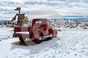 Red vintage pickup truck in snow in California high desert