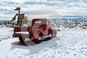 Red vintage pickup truck in snow in California high desert photo