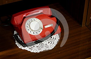 Red vintage telephone with a phone on the table