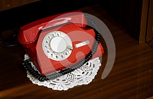 Red vintage telephone with a phone on the table