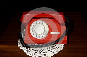 Red vintage telephone with a phone on the table