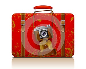 Red vintage threadbare suitcase with a retro photo camera