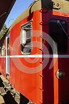 Red vintage train locomotive stationed at a station