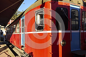 Red vintage train locomotive stationed at a station