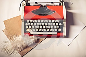 Red vintage typewriter with white blank paper sheet