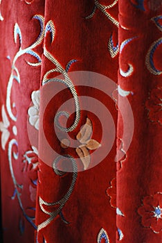 red vintage velvet curtain with flowers and golden ornaments