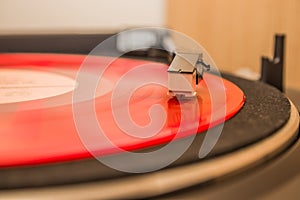 Red vinyl record close up. Old school record player .retro record vinyl player. The red plate is spinning in the vinyl player