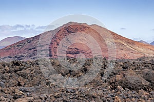 Red volcano near Los Hervideros caves in Lanzarote, Canary Islands.