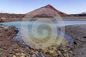 Red volcano near Los Hervideros caves in Lanzarote, Canary Islands.