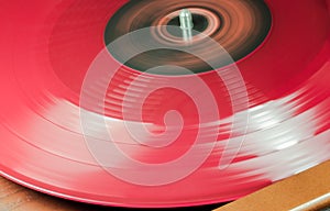 A Red Vynil Disc is being played in a player