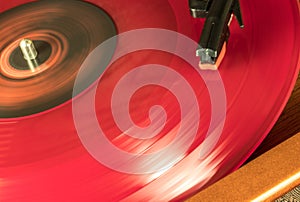 A Red Vynil Disc is being spinned in a player