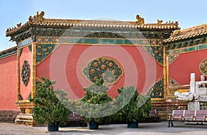 Red wall with green ceramic decorations in the Imperial palace Forbidden City.