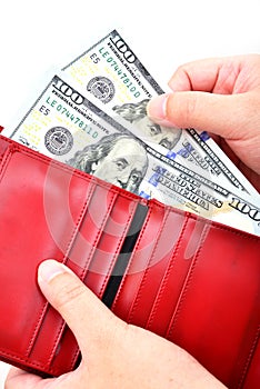 Red wallet with US dollars in the hands