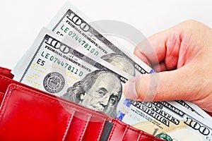 Red wallet with US dollars in the hands