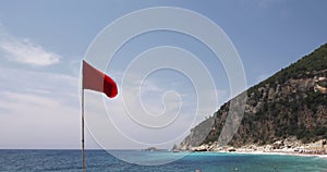 Red warning flag on the beach blue sea, sky and land in the background â€“ Wind and Sea Summer Video