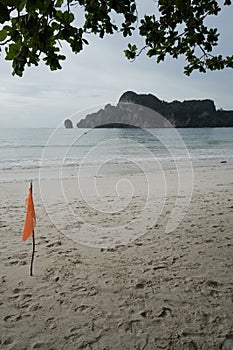 A red warning flag on a tropical beach