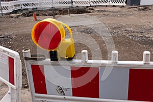 A red warning light with street barriers at a construction site