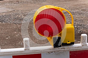 A red warning light with street barriers at a construction site