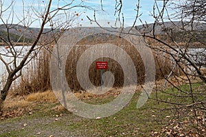 Red warning sign by the lake: