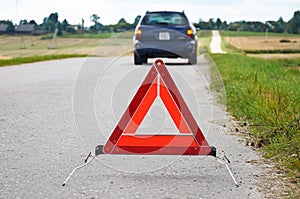 Red warning triangle and broken down car
