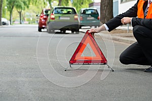 Red warning triangle with a broken down cars