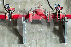 Red water or gas pipeline with gate pressure valve on concrete wall. Industrial tubes and valves, Line pipe industrial and